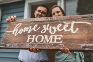 couple holding a Home Sweet Home sign