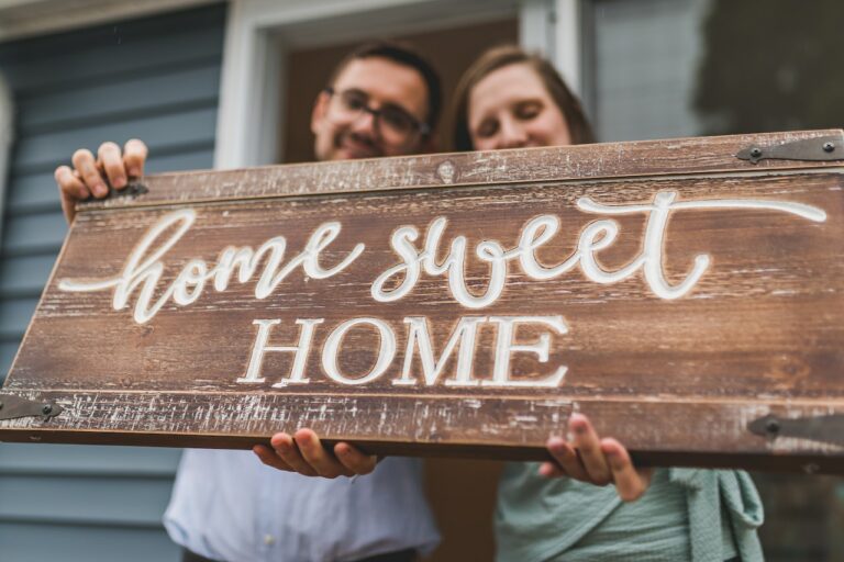 couple holding a Home Sweet Home sign